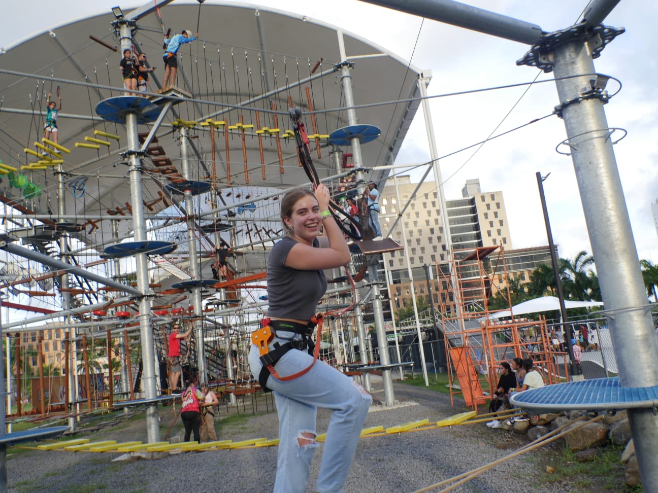 Participante con arnés en el circuito de cuerdas de Aventura, bajo el toldo del parque